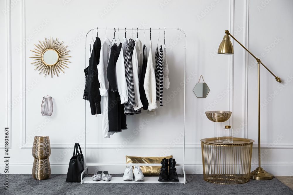Rack with stylish clothes near white wall in dressing room - obrazy, fototapety, plakaty 