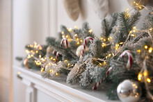 Beautiful Decoration Of Fir Tree Branches, Candy Canes, Fairy Lights And Christmas Balls In Room, Closeup
