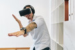 © DragonImages - Happy excited young man in virtual reality glases making gestures when fighting with enemy in videogame