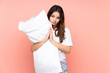 © luismolinero - Young woman in pajamas isolated on pink background pleading