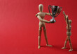 Wooden puppets holding winner cup on red background