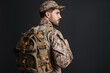 © Drobot Dean - Confident masculine military man in uniform posing with backpack