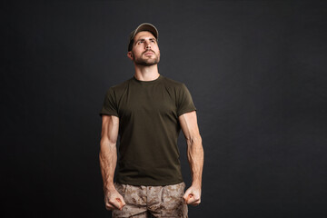 Wall Mural - Confident masculine military man posing and looking upward