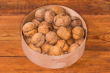 Wall Mural - Walnuts in shells in wooden round box on rustic table