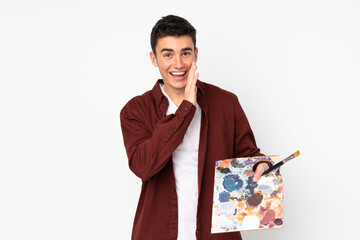 Wall Mural - Teenager artist man holding a palette isolated on white background whispering something