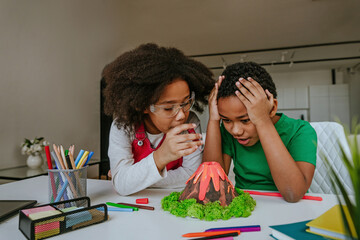 Children making DIY volcano model from kids play clay