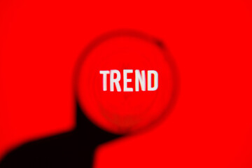 Text trend on red screen through magnifying glass.