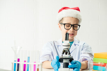 student learning chemistry. positive joyful smart boy testing and using a microscope in science clas