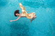 © ullision - beautiful sexy young woman mermaid in gold dress, cloth floats weightless elegant in the blue turquoise spa pool water