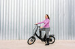© expressiovisual - 40-year-old woman riding her electric bicycle through the streets of the city