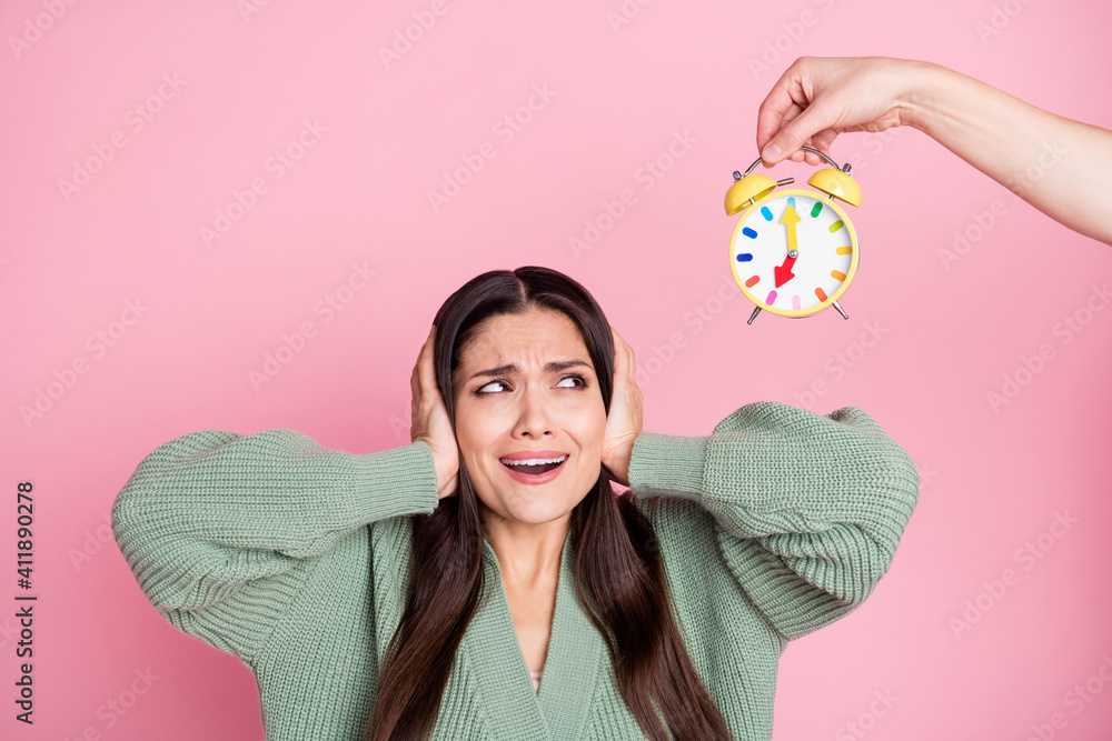 Photo of girl close ears scared worried look alarm clock wear green cardigan isolated pastel pink color background - obrazy, fototapety, plakaty 