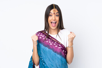 Young Indian woman isolated on white background celebrating a victory in winner position