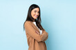 © luismolinero - Young caucasian woman isolated on blue background with arms crossed and looking forward