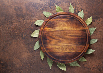 Wall Mural - Pizza or bread cutting board and laurel leaf for homemade baking on table