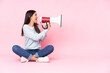 © luismolinero - Young caucasian woman isolated on pink background shouting through a megaphone