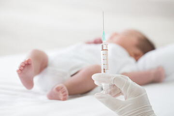 Wall Mural - Syringe with blur baby background. Vaccine antivirus for infant .concept