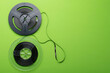 on a green background, two retro magnetic coils for listening to music, on the right there is a place for the inscription