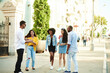 © etonastenka - Young people having fun outdoors. A group of multi-ethnic friends are talking and laughing while standing in the street