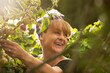 © Martin Barraud/Caia Image - Happy woman laughing in sunny summer vegetable garden