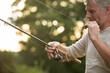 © Martin Barraud/Caia Image - Man preparing fly fishing line