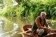 © Martin Barraud/Caia Image - Portrait happy man fly fishing in boat on river