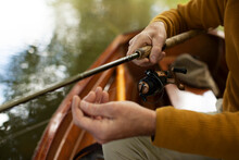 Close Up Man Adjusting Fly Fishing Line In Boat