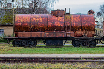 A single old rusty oil train car wagon on a railway