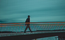 Man Crossing The Footbridge At Night