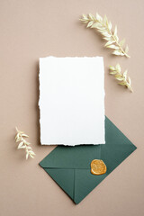 Wall Mural - Wedding details card template. Blank paper card and green envelope with dried flowers. Flat lay, top view, copy space.