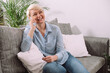 © LunaLu - Happy Cheerful Young Woman Talking on Phone at Home Woman Relaxing on Sofa With Smartphone.