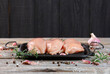 Raw chicken breast with fresh rosemary, garlic and pepper on wooden background. Chicken fillet on grill