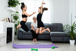 © Angelov - senior grandmother workout yoga withgranddaughters preschooler. They are sitting on mat at cozy home interior. Sport, parenthood and people concept