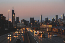 City Skyline And Cars Driving Along Freeway At Sunset, Chicago, Illinois, USA