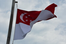 Low Angle View Of Singaporean Flag Against Sky