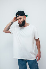 young bearded hipster guy wearing white oversized blank t-shirt on a white background. mock-up for p