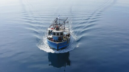 Wall Mural - Small Fishing boat sailing across calm smooth Sea, Aerial view.
