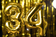 The Golden Number 34 Thirty Four Is Made Of An Inflatable Balloon On A Yellow Background. One Of The Complete Set Of Numbers. Birthday, Anniversary, Date Concept