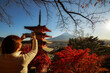 Woman taking photo on Mount Fuji with cell phone,view of Chureito pagoda and Mt. Fuji in autumn.