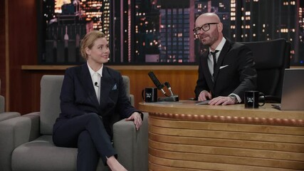 Wall Mural - ZOOM IN Late-night talk show host having a conversation with celebrity female guest in a studio. TV broadcast style show. Shot with RED cinema camera