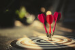 © kunakorn - Close up shot of the dart arrow hit on bulleyes of dartboard to business. Dart is an opportunity and Dartboard is the target and goal.