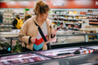 © Jacob Lund - Customer reading product information at supermarket