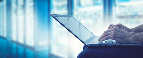 server support and management - it technician working on laptop in data center server room. copy space