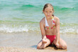 Beautiful girl on a sandy beach, green sea in background