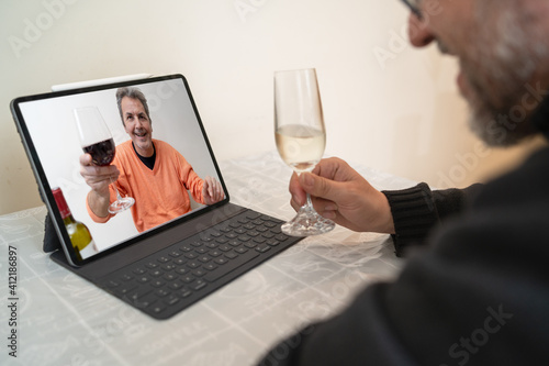 Adult people safety drinking alcohol during coronavirus pandemic. Mid aged man meets online thru a video conference call application