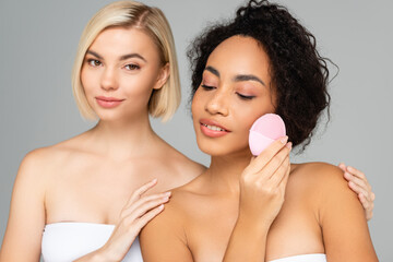 Wall Mural - Multicultural women posing with silicone brush isolated on grey