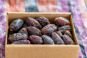 Raw and organic Medjool date fruit in paper box package.