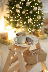 Wall Mural - Tasty hot drink and cookies in room with Christmas tree