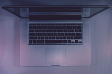 Aufkleber - Beautiful silver laptop in the color light on a table and night background. Macro  photography view. Close-up of pixel.