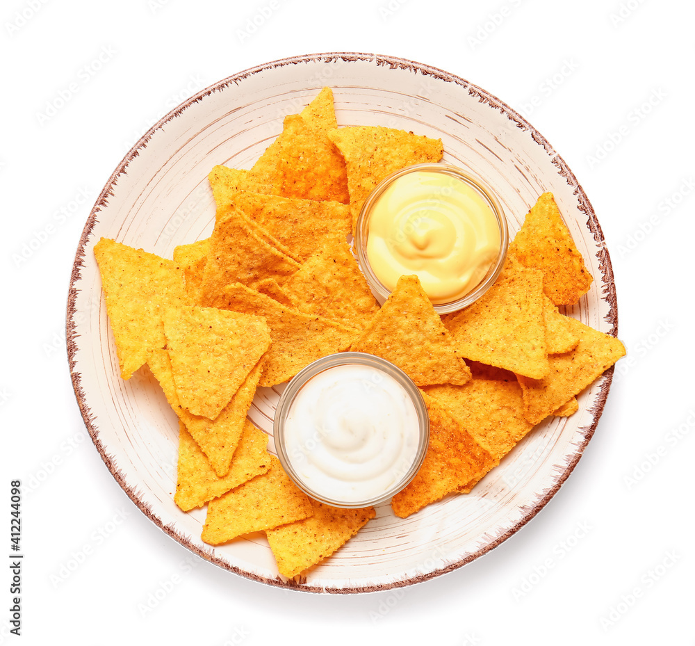 Plate with tasty nachos and sauces on white background
