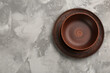 © New Africa - Brown clay bowl and plate on grey table, top view. Space for text